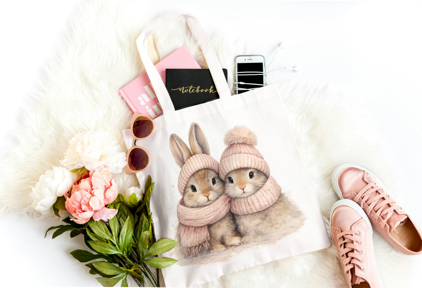 Notebook with rabbit illustration, pink shoes, flowers, and sunglasses on a white surface
